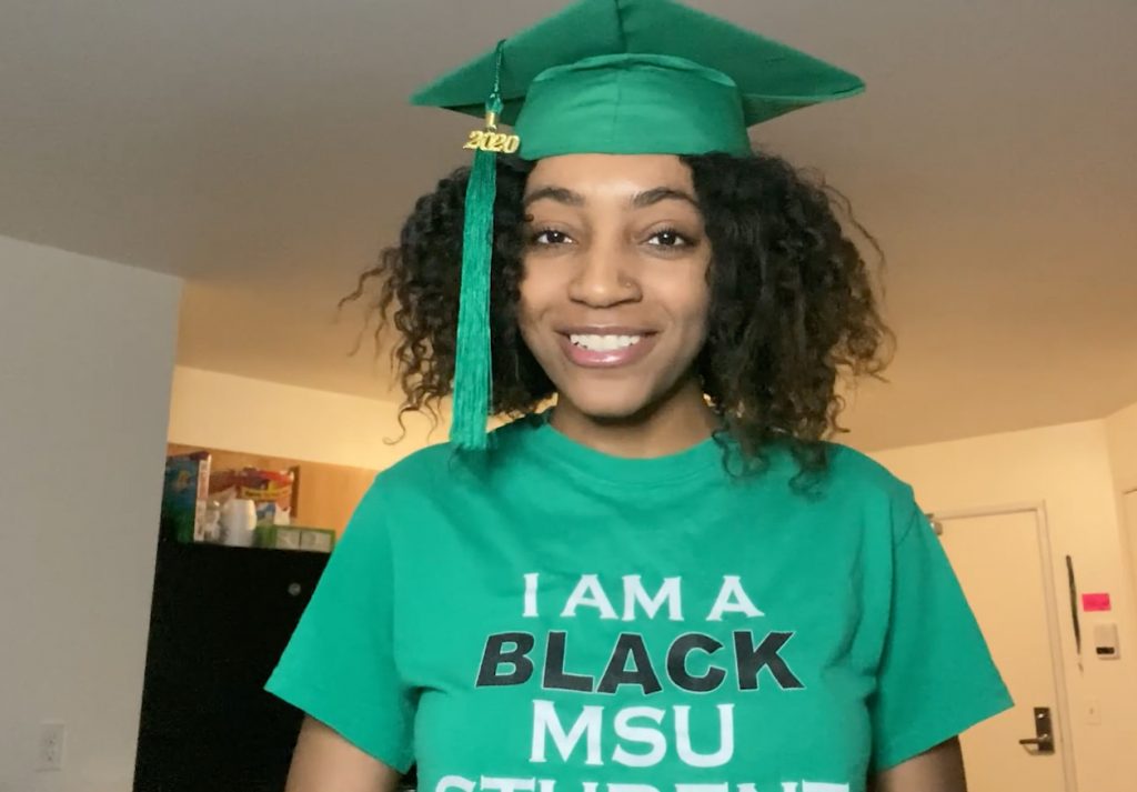 Young woman wearing a green graduation cap