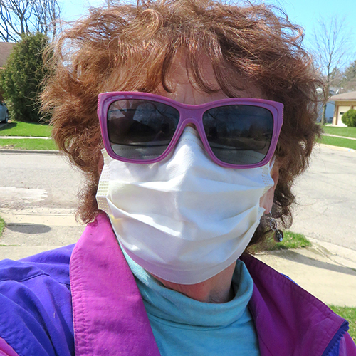 Woman in purple sunglasses and wearing a medical mask