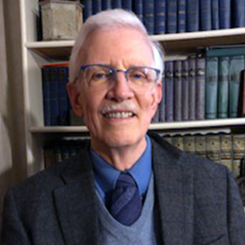 Older man with glasses wearing a tie and suit jacket